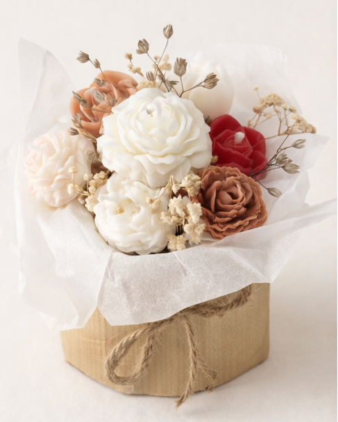 Handgemachter Blumenkerzenstrauß aus Rapswachs in Creme- und Rosétönen, dekorativ arrangiert als Geschenkidee.